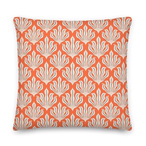 May include: Orange throw pillow with a white and navy blue geometric pattern of stylized leaves.
