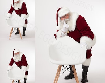 May include: Santa Claus in a red suit and white beard is peeking over the back of a white chair with wooden legs. He is holding his finger to his lips as if to say 'shhh'.
