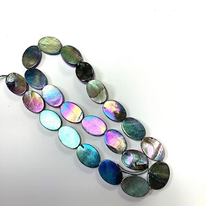 May include: A strand of oval-shaped beads made from iridescent shell material. The beads display a spectrum of colors including deep blues, vibrant purples, greens, and hints of pink, reflecting light with a pearlescent, multi-colored finish.