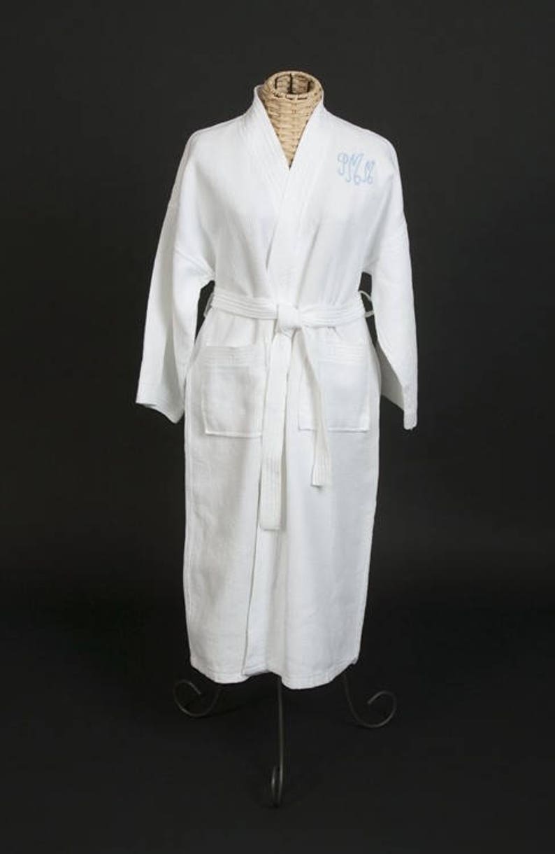 May include: White waffle weave robe with a long sleeve and a self-tie belt. The robe has a monogrammed "M.M." on the left chest.