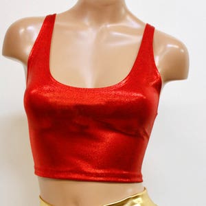 Pode incluir: Um top vermelho curto com shorts de estampa de estrelas azuis e brancas. Os shorts t&ecirc;m uma cintura dourada.