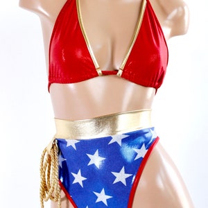 May include: Red and gold halter top bikini with a blue and white star print bottom. The bottom has a gold belt and a gold rope tie.