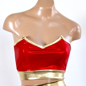 May include: Red strapless top with gold trim. The top has a sweetheart neckline and a gold band around the bottom.