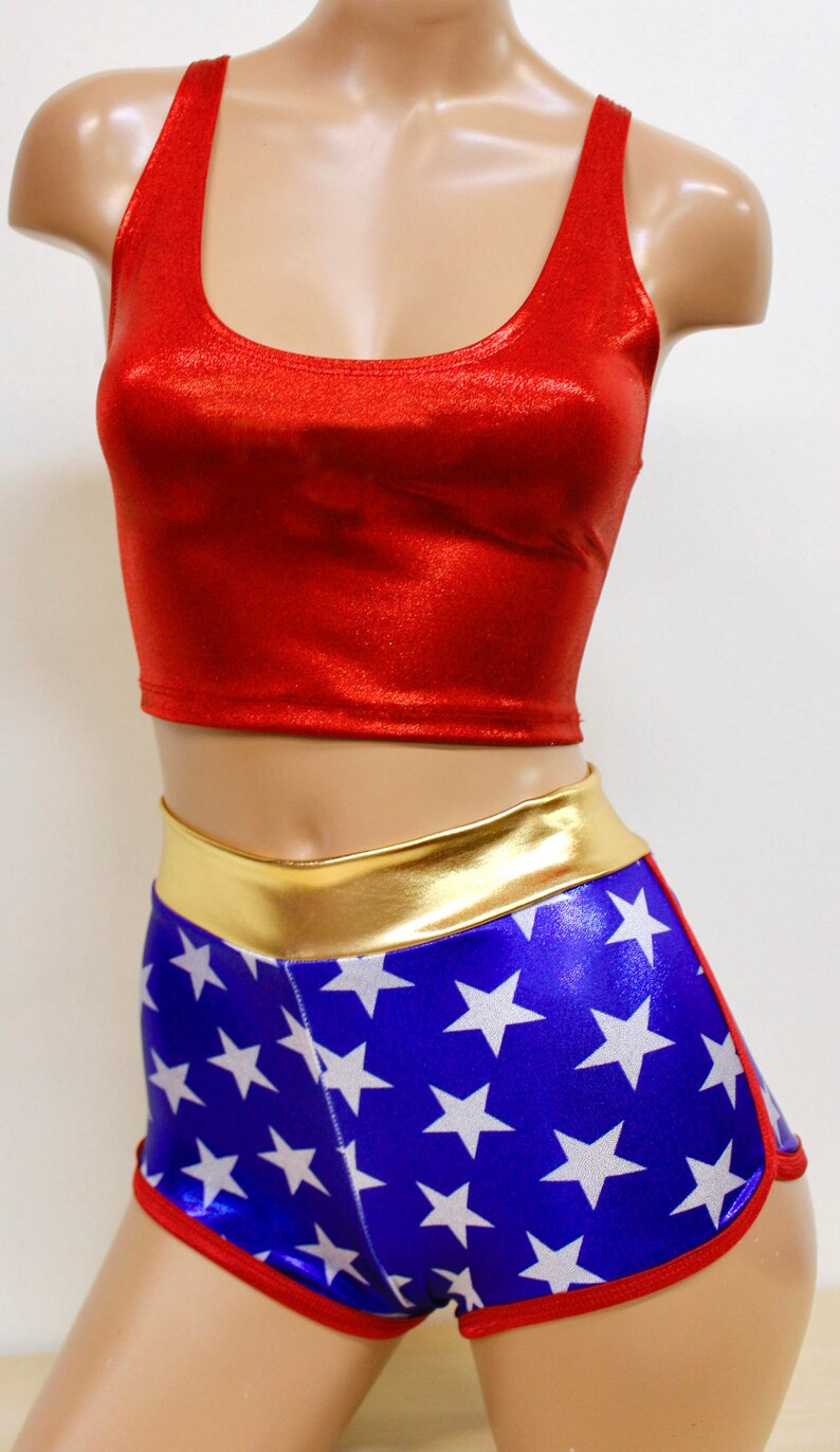 Pode incluir: Um top vermelho curto com shorts de estampa de estrelas azuis e brancas. Os shorts t&ecirc;m uma cintura dourada.