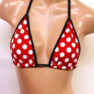 Könnte beinhalten: Roter Bikini-Oberteil mit weißen Punkten und schwarzem Besatz. Das Oberteil ist im Dreieckstil mit verstellbaren Trägern.
