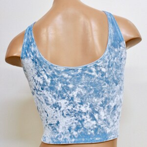 May include: A light blue crushed velvet tank top with a scoop neck and thin straps.