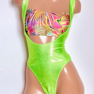 Op de afbeelding: Een limoengroen pakje met een uitsnijding in de taille en een kleurrijk abstract geprint bandeau-top.