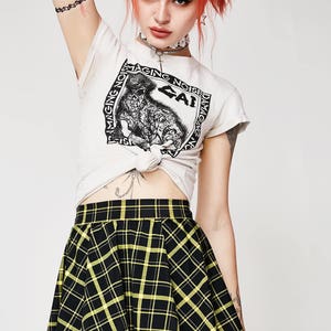 May include: A black and yellow plaid mini skirt with a high waist and a flared silhouette.