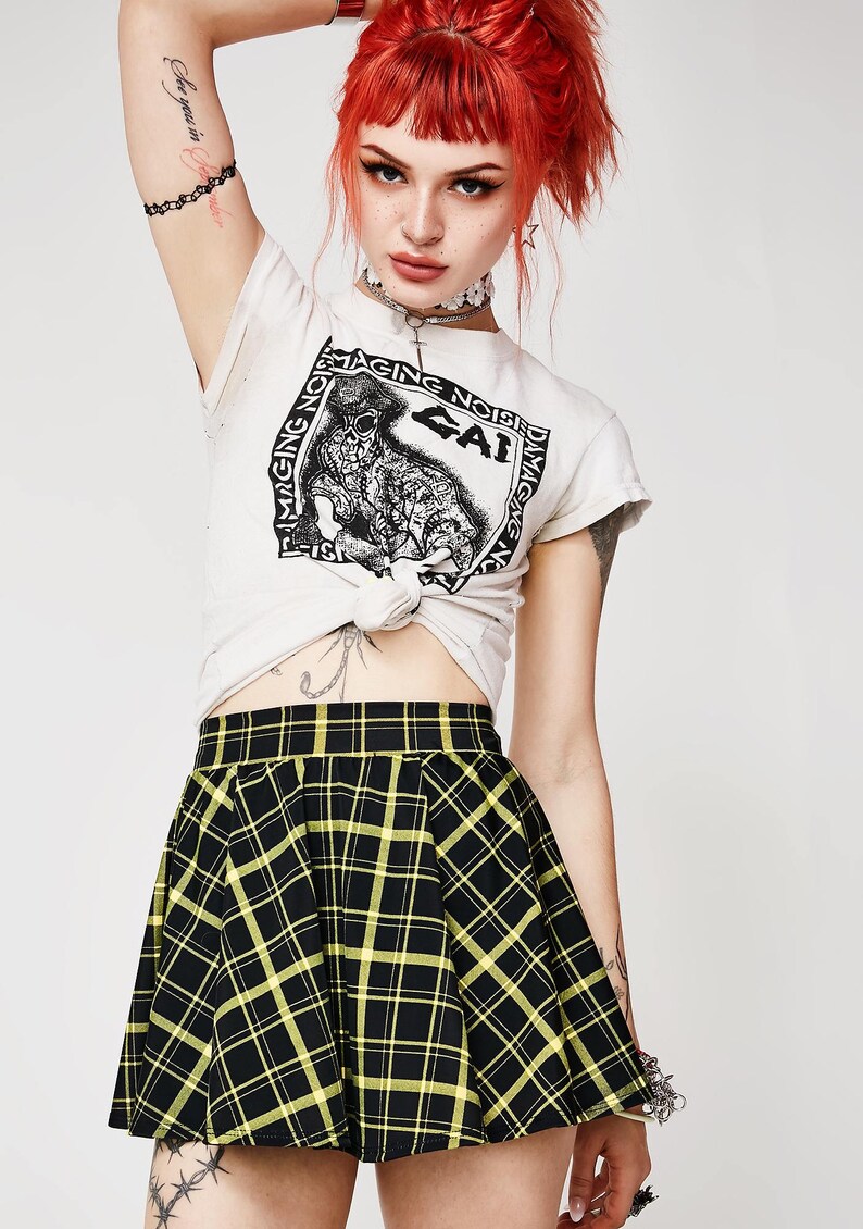 May include: A black and yellow plaid mini skirt with a high waist and a flared silhouette.