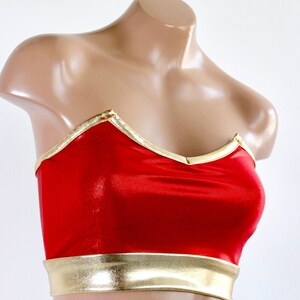 May include: Red strapless top with a gold trim. The top has a sweetheart neckline and a fitted bodice.
