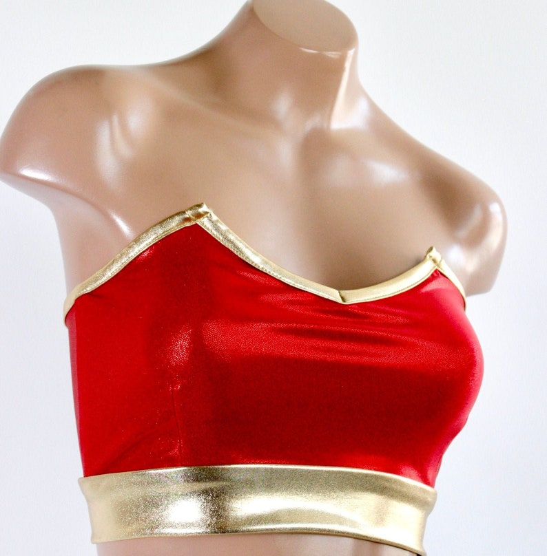 May include: Red strapless top with a gold trim. The top has a sweetheart neckline and a fitted bodice.