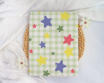 May include: A rectangular notebook featuring a light green and white gingham check pattern. The cover is decorated with scattered five-pointed stars in various sizes and colors, including yellow, purple, red, and olive green across the surface.