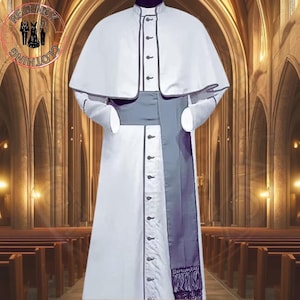 Może przedstawiać: Biała sutanna z peleryną i szarym pasem. Sutanna ma rząd guzików z przodu i czarną lamówkę na krawędziach. Pas jest zawiązany w talii i ma frędzle na dole.