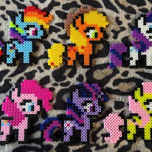 Könnte beinhalten: Ein Set aus sieben bunten My Little Pony-Charakteren aus Perlen. Die Ponys sind alle in verschiedenen Farben und haben unterschiedliche Designs.
