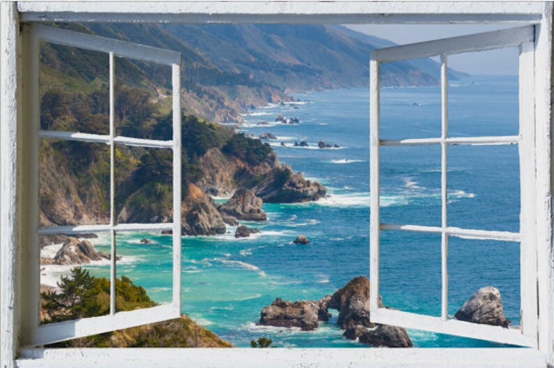 May include: A white window frame with a view of a rocky coastline and blue ocean. The window is open and the view is framed by the window panes.