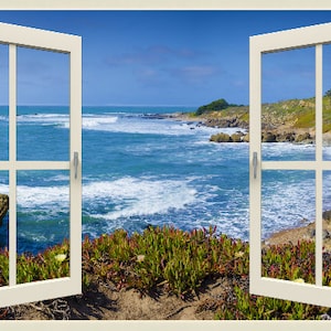 May include: A white window frame with two open windows looking out at a blue ocean with waves crashing on a sandy beach. Green plants are in the foreground.