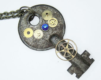 Tardis Key Necklace - comprised of gold bronze and brass gears with a deep blue crystal rhinestone - Post Apocalyptic Style jewelry