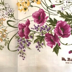 Pu&ograve; includere: Fazzoletto di cotone bianco con un motivo floreale con papaveri rosa, fiori gialli e foglie verdi. Il fazzoletto ha un'etichetta marrone che recita "Made in"
