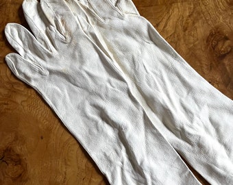 May include: A pair of long white leather gloves. The gloves are made of a soft, supple leather and have a classic, elegant design.