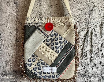 May include: A patchwork shoulder bag with a beige strap and a red button closure. The bag features a variety of fabrics, including patterned blue, gray, and beige textiles, with lace trim and the text "IVA NOVA".