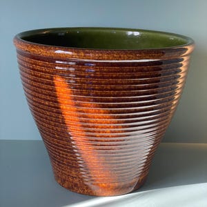 May include: A set of three ceramic mugs with a speckled, matte finish in cream, light grey, and dark grey. Each mug has a simple, minimalist design and a rounded handle.