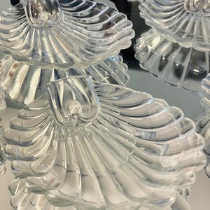 Op de afbeelding: Een witte keramische mok met een zwarte handgreep en de tekst "But First, Coffee" in een vetgedrukte, zwarte letter. De mok staat tegen een vage achtergrond, wat een gezellige setting suggereert.