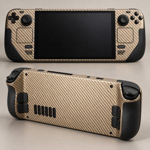 Pode incluir: Uma consola de jogos portátil com uma película texturizada de fibra de carbono dourada. A parte frontal apresenta um ecrã preto, um D-pad, dois sticks analógicos e botões de ação. A parte traseira mostra uma grelha e quatro botões.