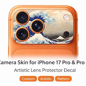 Könnte beinhalten: Orangene Kamera-Skin für iPhone 17 Pro & Pro Max. Das Skin zeigt ein künstlerisches Design einer blau-weißen Welle mit einem Berg im Hintergrund. Der Text auf dem Bild lautet "Camera Skin for iPhone 17 Pro & Pro Max" und "Artistic Lens Protector Decal."