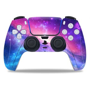 Puede incluir: Un mando de PlayStation 5 con temática de galaxia púrpura y azul con un logotipo de PlayStation en blanco y negro.