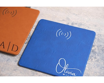 May include: A blue leather wireless charging pad with a white wireless charging symbol and the name "Olivia Wilson" in white cursive writing.