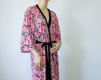 May include: A pink and black floral print robe with a black sash tie. The robe has a V-neck and 3/4 sleeves.