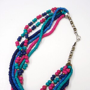 May include: Multi-strand necklace with pink, blue, and turquoise beads. The necklace has a silver clasp.