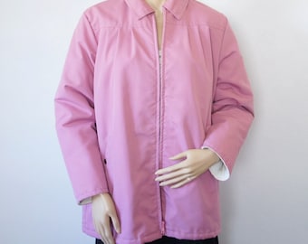 May include: A pink zip-up jacket with a collared neckline. The jacket has a smooth, slightly shiny finish.