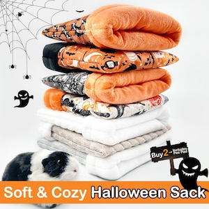 Könnte beinhalten: Ein Stapel weicher, kuscheliger Halloween-Säcke in Orange, Schwarz und Weiß mit verschiedenen Halloween-Mustern. Das Bild zeigt ein Meerschweinchen und den Text "Soft & Cozy Halloween Sack."