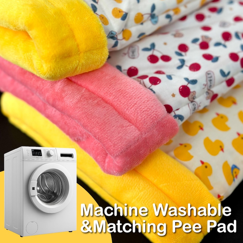May include: A stack of soft, colorful pet pads in yellow and pink, with a white pad featuring red cherries. A yellow pad with yellow ducklings is also visible. The text "Machine Washable & Matching Pee Pad" is displayed.