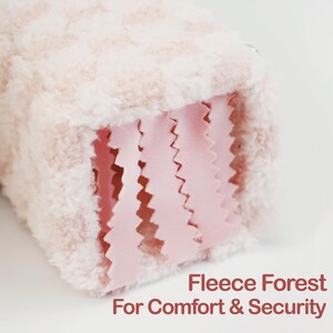 May include: A close-up of a soft, plush, pink and white fleece item. The item has a textured exterior and a pink, zig-zag cut interior. The text "Fleece Forest For Comfort & Security" is visible in the bottom right corner.