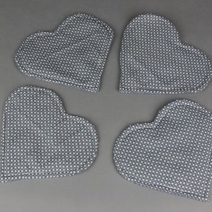 May include: Four blue heart-shaped fabric cushions with a white polka dot pattern.