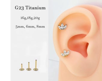 May include: Close-up of a titanium ear piercing with a small, clear crystal flower design. The piercing is shown in a model's ear. The image also shows three different sizes of the piercing, 5mm, 6mm, and 8mm.