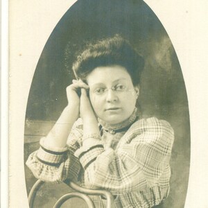 Cartão Postal Rosa Usando Óculos Sentada Encostada na Cadeira Azo RPPC Foto Real