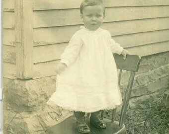 Little Boy in Dress Standing Outside on Chair Farm House 1900s Studio Portrait Antique RPPC Real Photo Postcard
