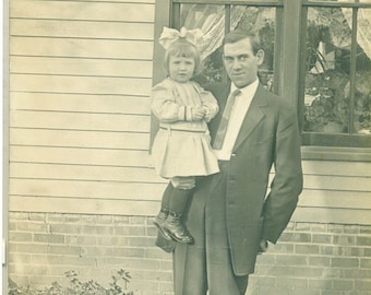 La fille de papa devient un homme lourd tenant sa fille AZO RPPC Real Photo Postcard Antique Photograph