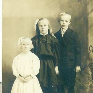1910er Jahre Geschwister überrascht unlächelnde Mädchen Blonde Junge Familie Portrait RPPC echte Foto Postkarte Foto schwarz weiß Foto
