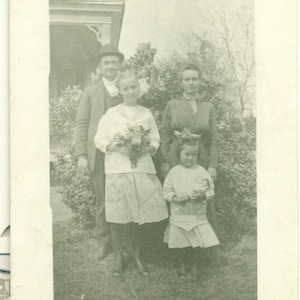 Fille tenant Doll Big Sister Holding Flowers Family Portrait 1910s RPPC Real Photo Carte postale Photographie Black White Photo