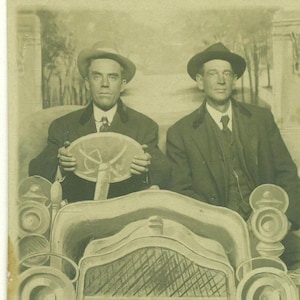 Homem dirigindo um carro de papelão novidade estúdio retrato RPPC foto real cartão postal foto preta e branca