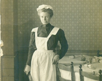 La femme de chambre du personnel en uniforme debout à côté de la serveuse de table antique RPPC Carte postale avec photo réelle