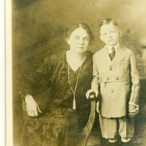 Madre inclinada para sostener los hijos mano 1920 mujer amor RPPC real foto postal fotografía negro blanco foto