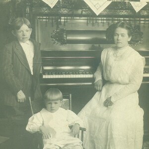 Jungen Mädchen sitzt am Klavier krumm kleinen Bruder Antik RPPC Real Photo Postkarte Fotografie schwarz weiß Foto