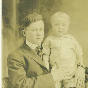 Big Brother Halten kleine Junge große Hände halten ihn noch 1910er Jahre RPPC echte Foto Postkarte Foto schwarz weiß Foto