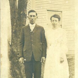 Ernest & Matilda Keys Skinny Couple Mari Femme debout à l’extérieur de la maison des années 1910 RPPC Real Photo Carte postale vintage Photographie