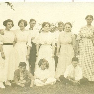 Mischievous Boys Sitzen Kreuz bebeizt vor Frauen plaid Kleid Familie Gourp 1910er Jahre RPPC echte Foto Postkarte Foto schwarz weiß Foto